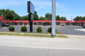 A motel with a red roof and multiple rooms. - Guest House Motel (Carthage)
