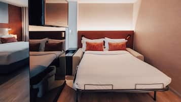 Habitación pequeña con una cama nido, una cama individual y un escritorio.
