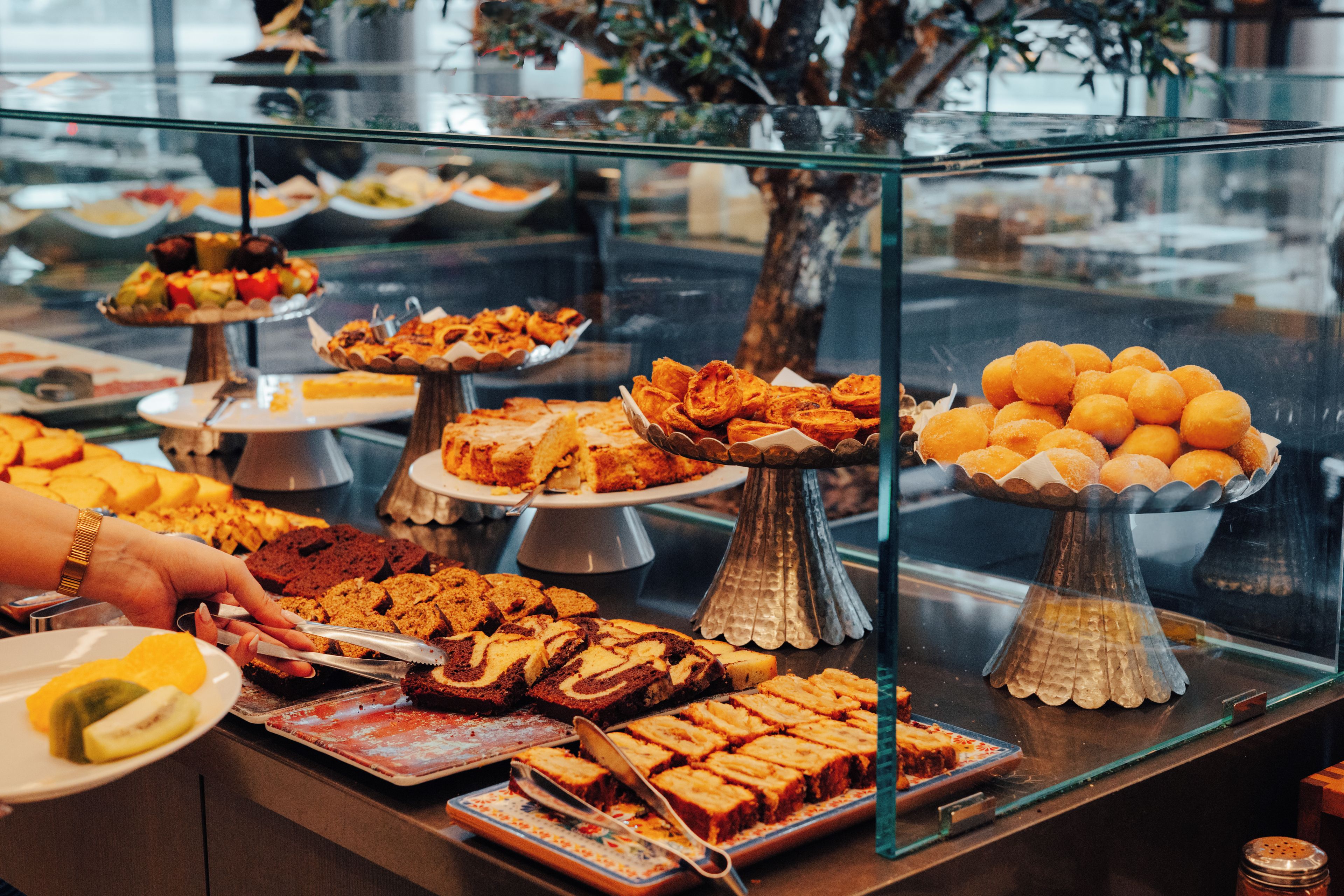 Een buffet met verschillende soorten eten gepresenteerd op meerdere toonbanken.