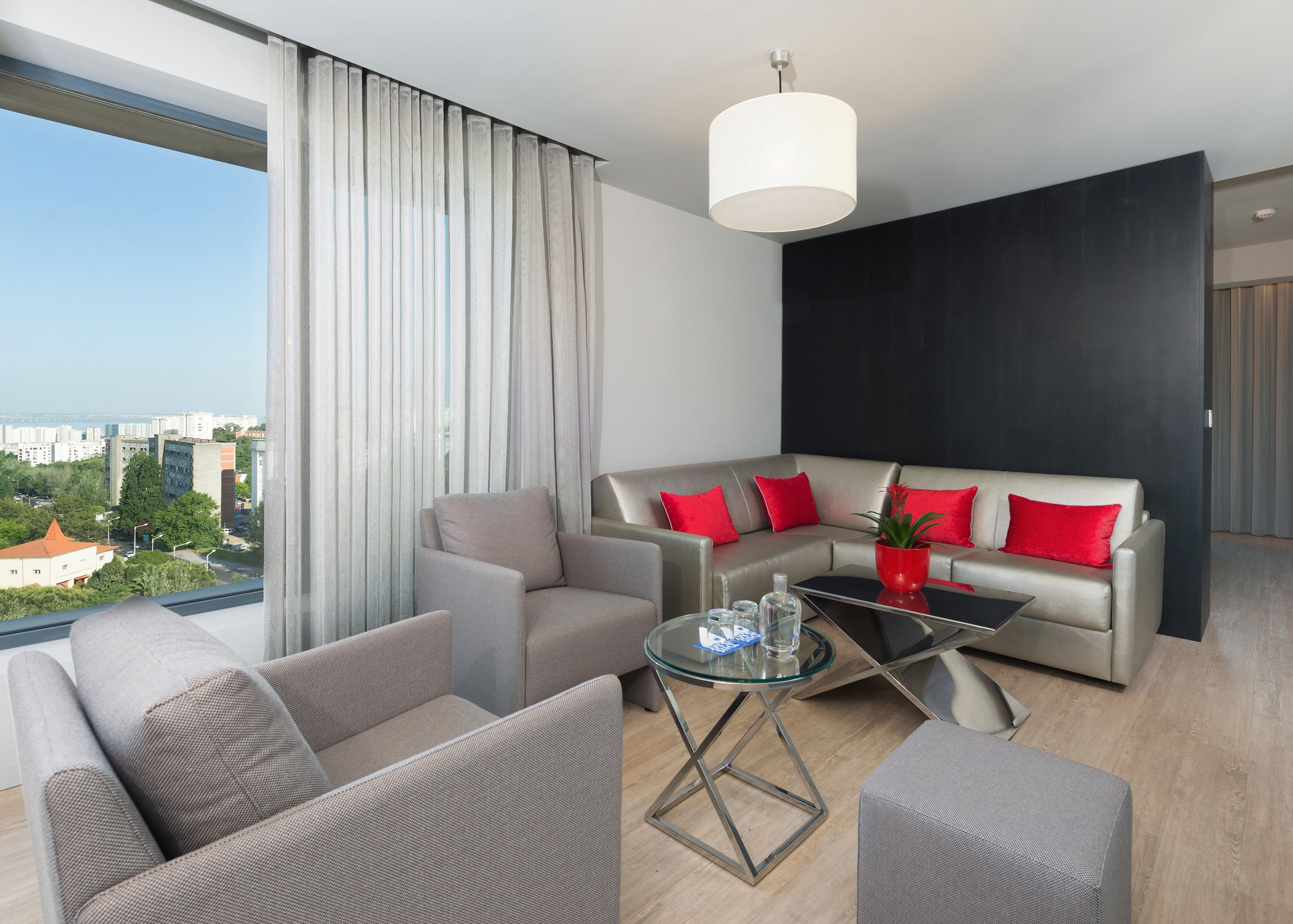 Un soggiorno moderno con un divano, un tavolino in vetro e vista sulla città.
