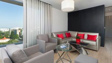 Un soggiorno moderno con un divano, un tavolino in vetro e vista sulla città.