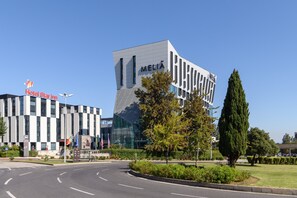 Een modern hotel met een glazen gevel en een heldere lucht.