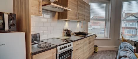 Chambre avec lits jumeaux, salle de bains attenante, vue partielle sur la mer | Cuisine privée