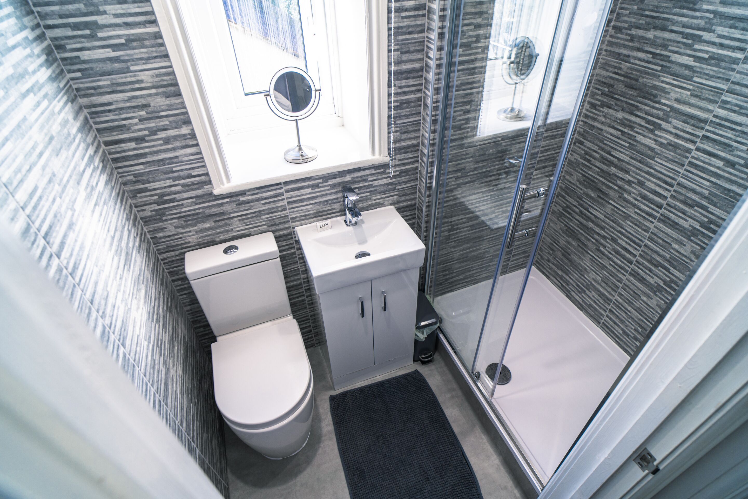 Ein Badezimmer mit Toilette, Waschbecken und Duschbereich.