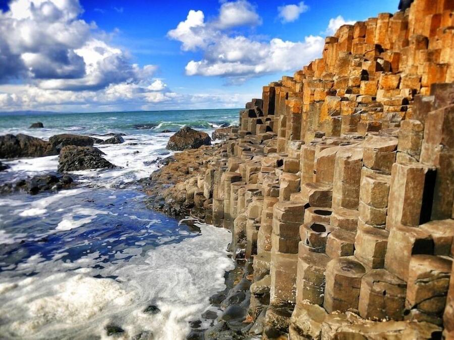 Edificio costiero in pietra con vista aperta sull'oceano e sul cielo.