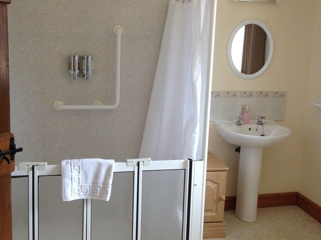 A bathroom with a shower, a sink, and a mirror.