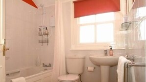 A bathroom with a bathtub, toilet, and sink. - Craglands Guest House (Keswick)