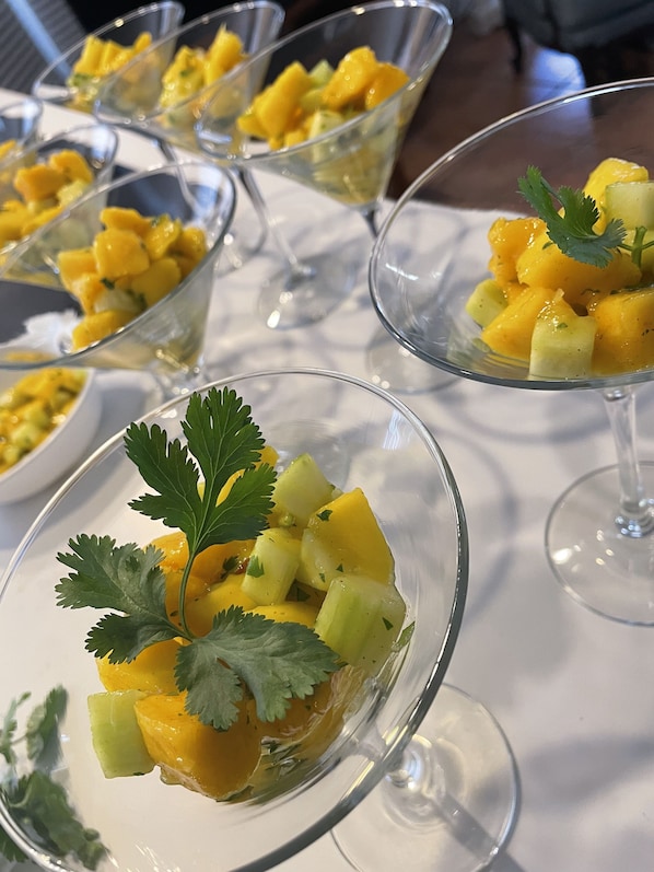 A table with several clear glass dessert glasses containing mango chunks and garnished with cilantro. - The Penrose Bed and Breakfast (Sedona)