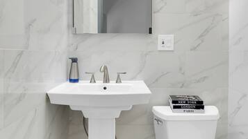 Ein Badezimmer mit Waschbecken, Spiegel und Toilette.