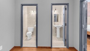 Une salle de bain moderne avec des toilettes, un lavabo, un revêtement de sol en bois et un miroir.