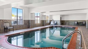 An indoor swimming pool with a tiled deck, a lifeguard chair, and a view of the outside. - Best Western St. Louis Airport North Hotel & Suites (Hazelwood)