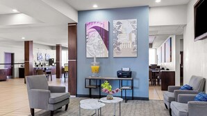 A hotel lobby with a reception desk, seating area, and artwork on the walls. - Best Western St. Louis Airport North Hotel & Suites (Hazelwood)