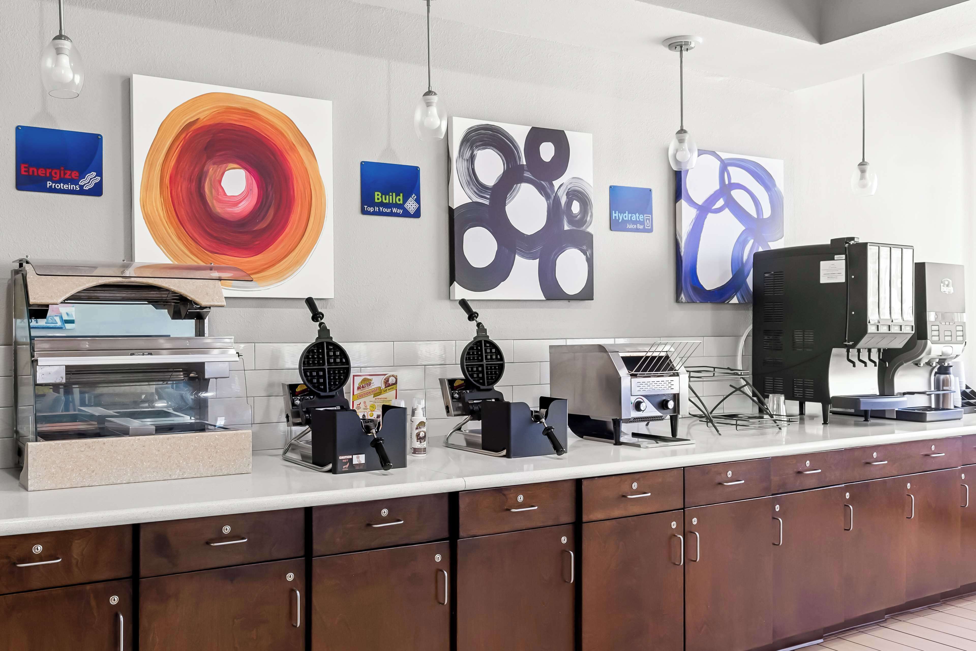 Un comptoir de cuisine avec des gaufriers, une machine à café et une pancarte indiquant « Energize Proteins ».