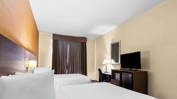 Ein Hotelzimmer mit zwei Betten, einem Schreibtisch, einem Fernseher und einer Minibar.