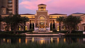 A hotel with a central courtyard, a reflective pool, and a large building with a prominent entrance. - Four Seasons Resort Orlando at WALT DISNEY WORLD® Resort (Lake Buena Vista)