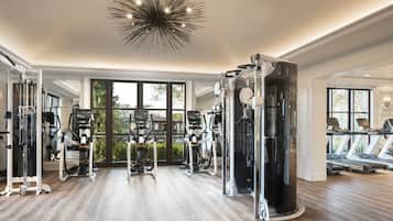 Uma academia espaçosa com diversos equipamentos de exercício, grandes janelas e um design de teto moderno.