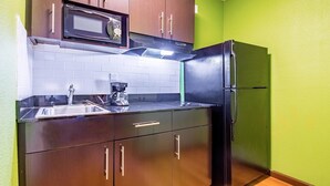 A compact kitchen with a microwave, coffee maker, and refrigerator. - Studio 6 Cypress, CA (Cypress)