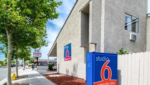 A building with a sign for 'Studio 6 Extended Stay' and a 'Dalton's Cafe' sign in the background. - Studio 6 Cypress, CA (Cypress)