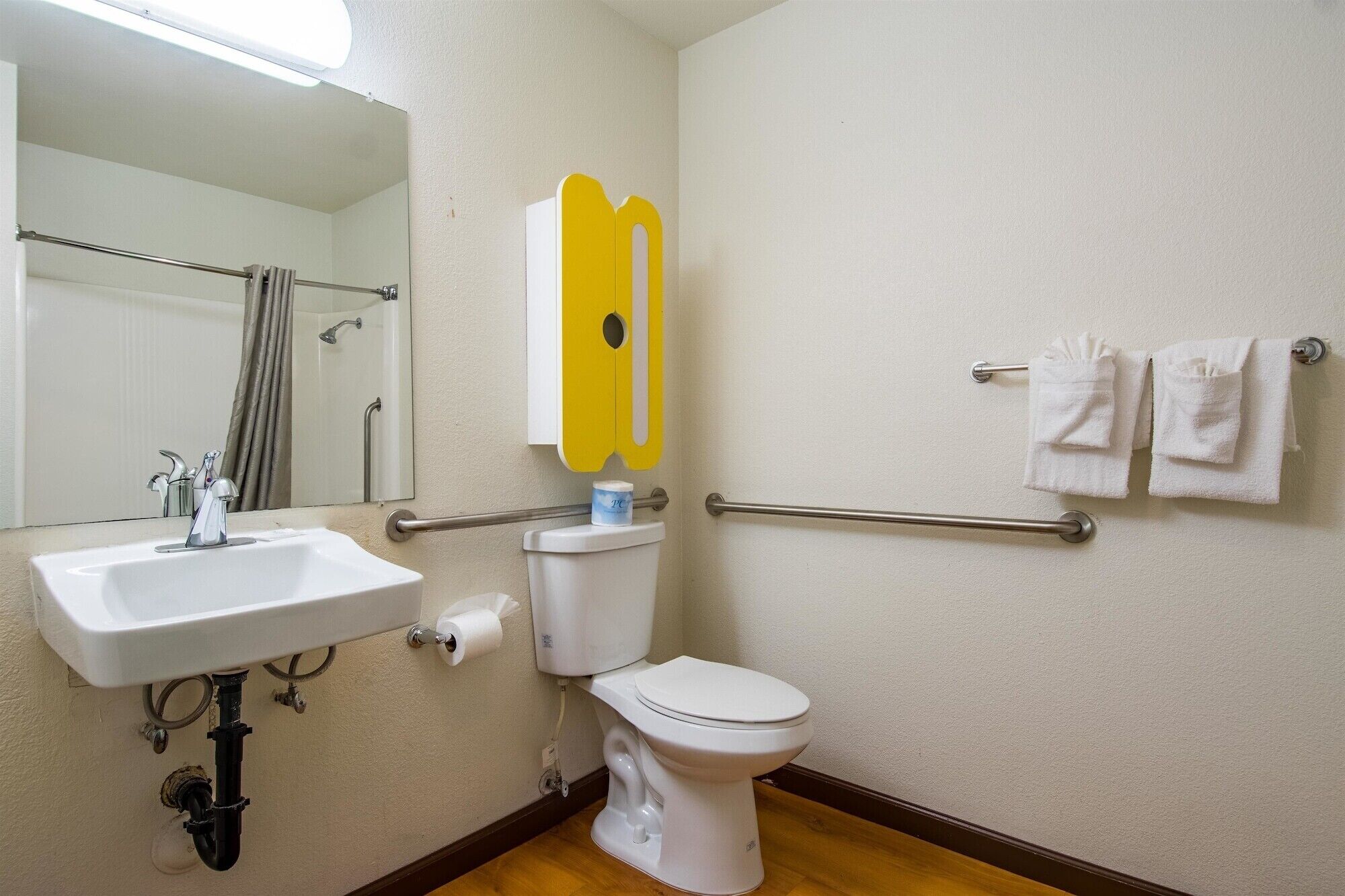 A bathroom with a sink, toilet, and towel rack.