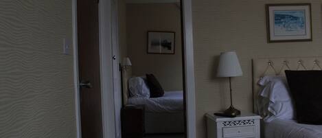 Habitación de hotel con cama, mesita de noche, lámpara y un cuadro en la pared.