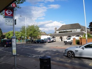 A street view with a request stop sign, a sign for Avondale Drive, and a hotel named 'Heatherwood Inn Hotel'. - Heathrow Inn (Hayes)