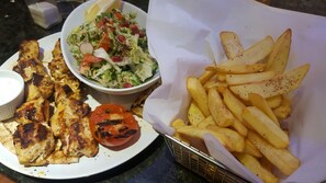 A plate of grilled chicken, a salad, and a basket of fries. - Heathrow Inn (Hayes)