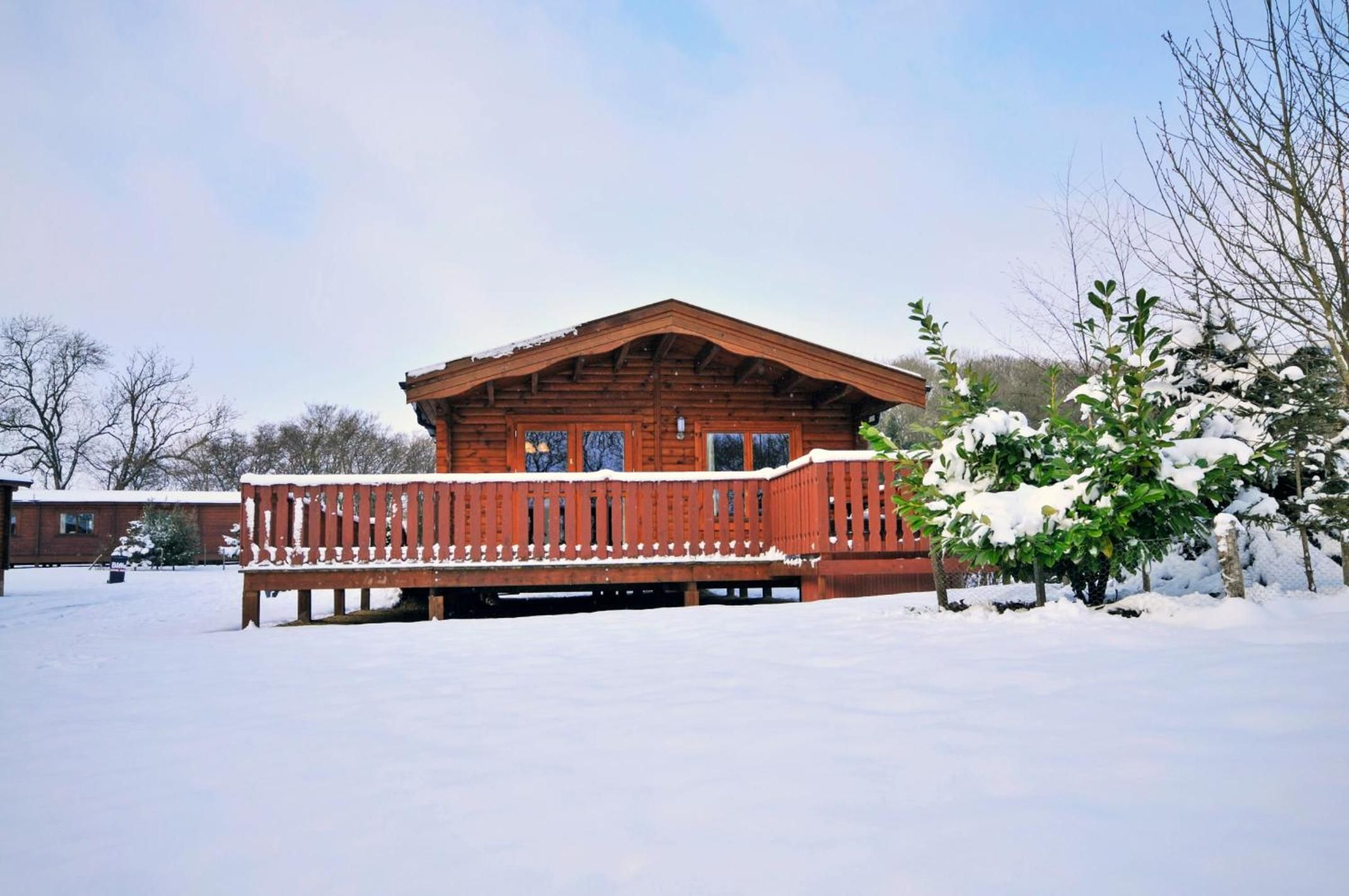 Eine Holzhütte mit einem Balkon, umgeben von Schnee.