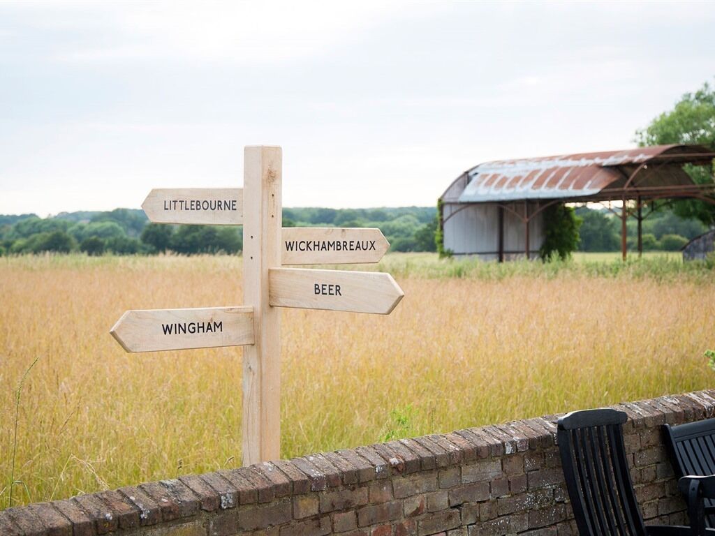 A wooden signpost with directions to Littlebourne, Wickhambreaux, Beer, and Wingham.