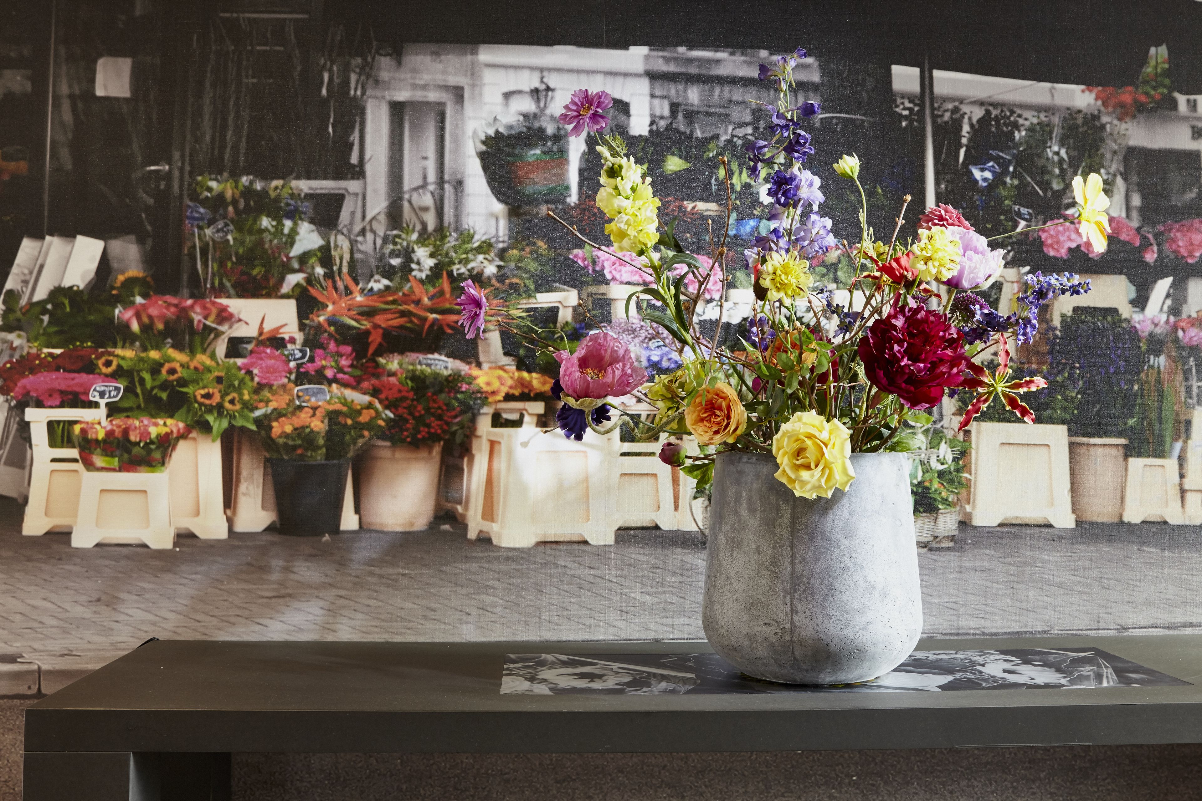 A flower arrangement in a concrete pot on a table.