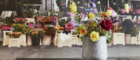 A flower arrangement in a concrete pot on a table.