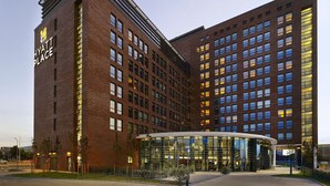 Un hôtel moderne doté d’une façade en briques remarquable, de grandes fenêtres et d’un hall d’entrée en verre.