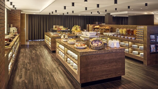 Un buffet proposant une variété de plats et d’ustensiles, un mur en briques et un plancher en bois.