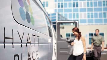 Una camioneta con la marca Hyatt Place frente a un edificio moderno.