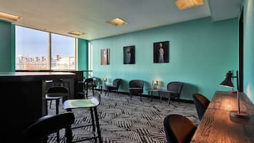 Una habitación moderna con un ventanal grande, una zona de bar y varias sillas.