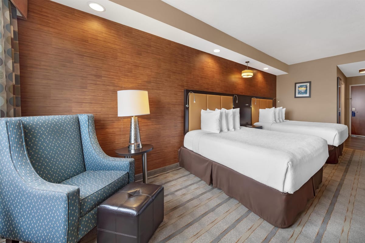 Ein Hotelzimmer mit einem großen Bett, zwei Nachttischen, einem Sofa und einer Lampe.