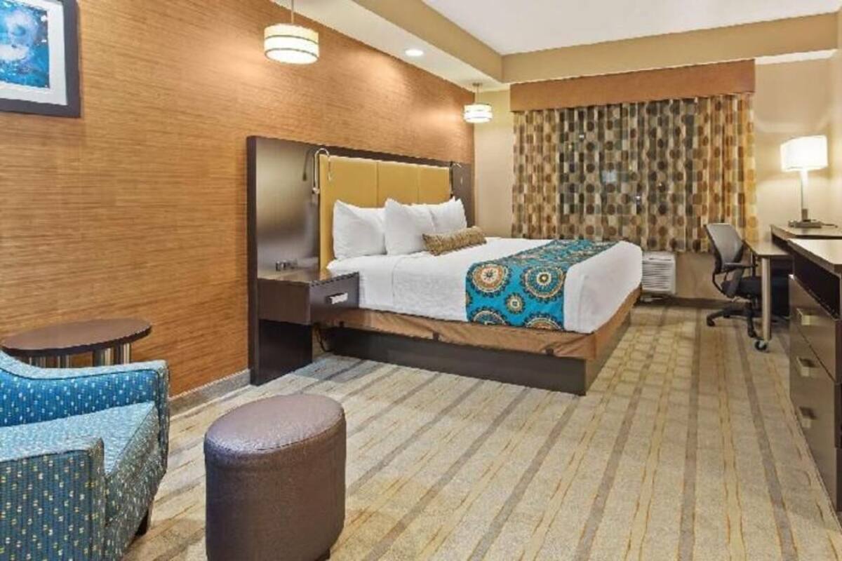 Une chambre d’hôtel équipée d’un lit, d’un bureau, d’une chaise et d’un téléviseur.