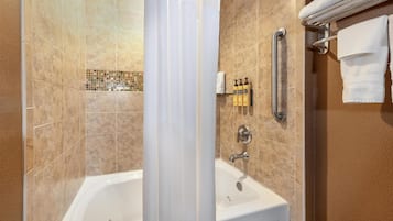 Un baño con bañera, zona de ducha y un perchero para toallas.