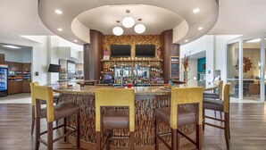 Un espace bar doté d’un bar circulaire, de nombreux types de sièges et d’un aménagement intérieur moderne.