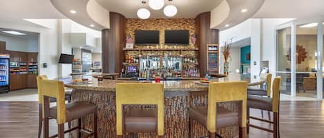 Un espace bar doté d’un bar circulaire, de nombreux types de sièges et d’un aménagement intérieur moderne.