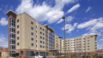 A hotel with multiple floors, large windows, and a parking lot.