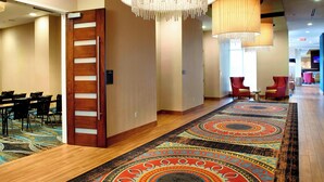 A hotel lobby with a long carpet, wooden floor, and a door with a vertical handle. - Residence Inn Secaucus Meadowlands (Secaucus)