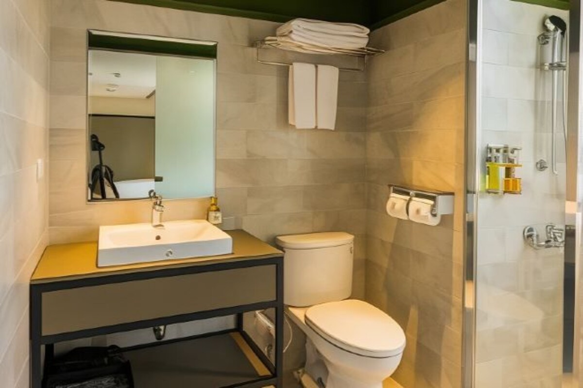A modern bathroom with a sink, toilet, and shower.