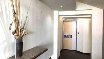 A hallway with a bench, a wall-mounted plant, and a door labeled "Laundry Room".