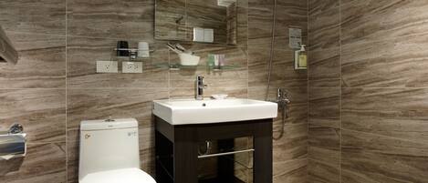 A modern bathroom with a toilet, sink, and shower.