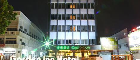 Ein mehrstöckiges Gebäude mit einem gut sichtbaren Schild 'Garden Inn Hotel'.