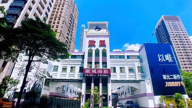 A modern hotel with a prominent entrance, large windows, and a clear blue sky in the background. - All Fun Business Hotel (Taichung)