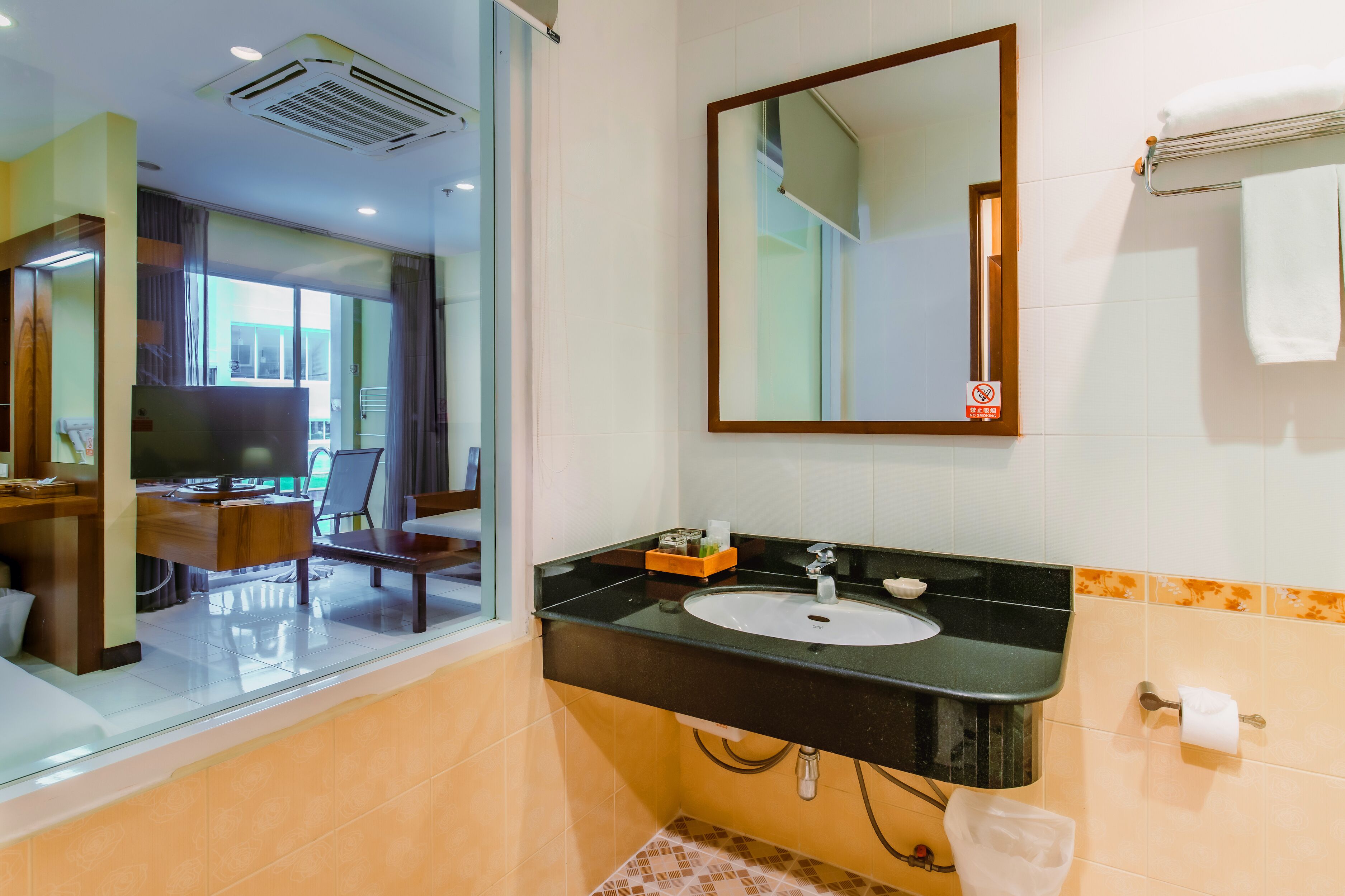 Une salle de bain moderne avec un lavabo noir, un miroir et une fenêtre.