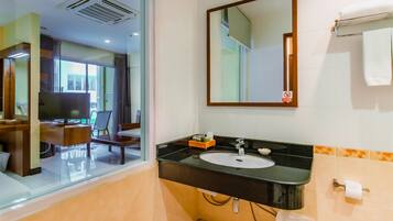 Une salle de bain moderne avec un lavabo noir, un miroir et une fenêtre.