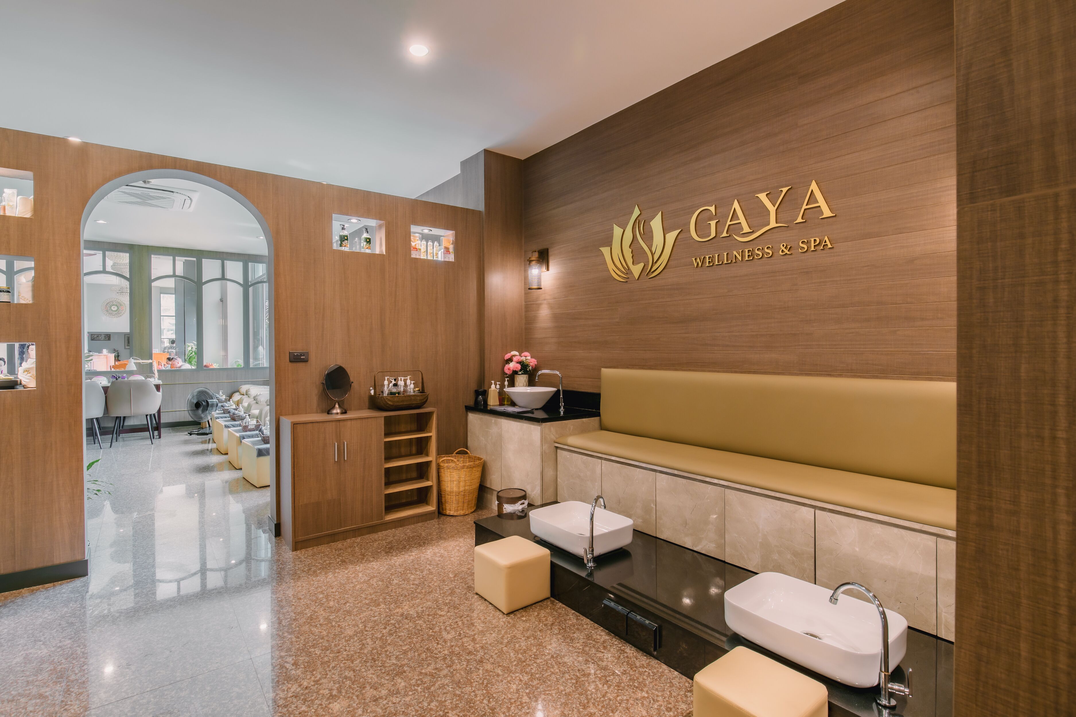 A modern wellness and spa area with a reception desk, seating area, and two sinks.