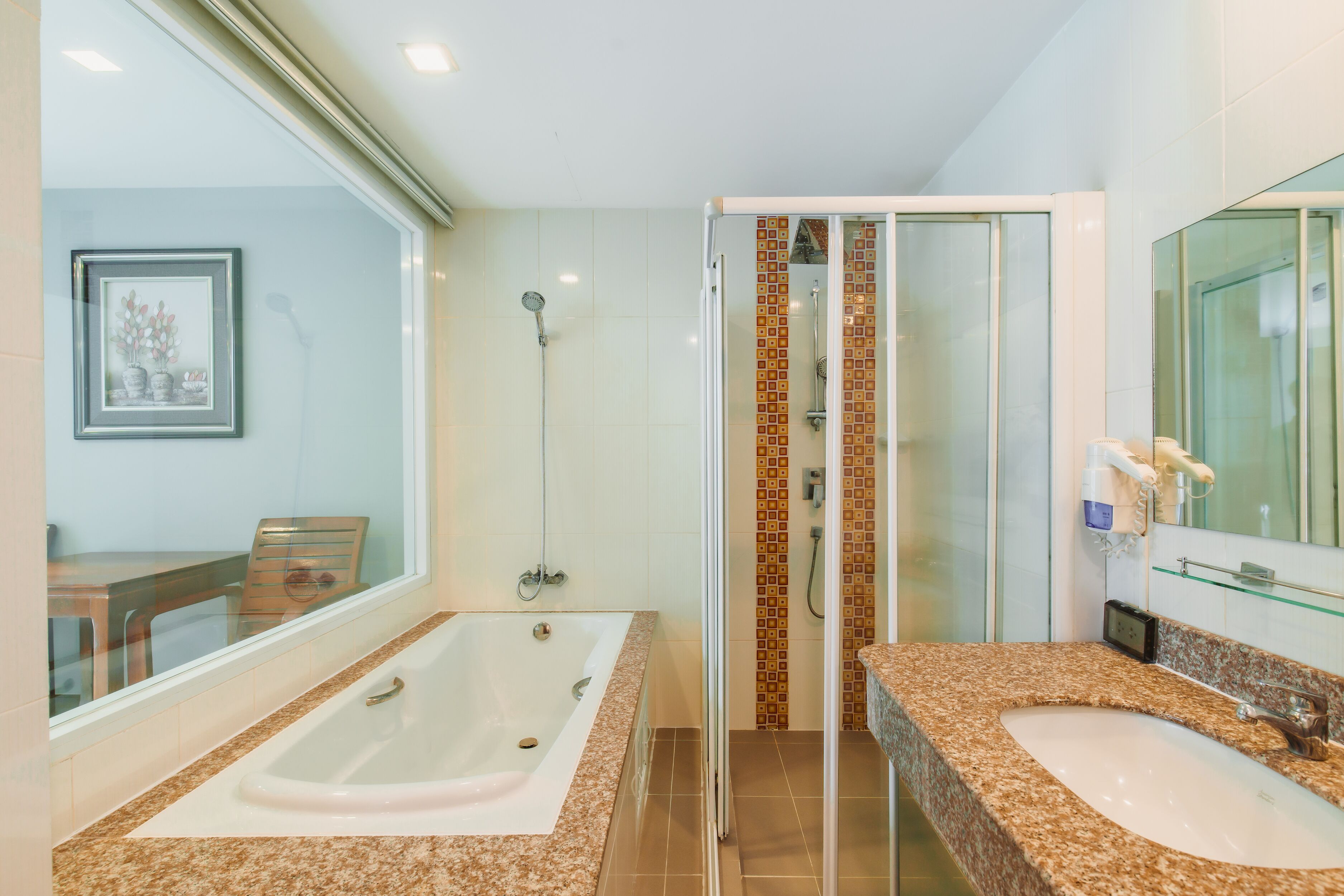 A bathroom with a large bathtub, a separate shower area, and a vanity with a sink.